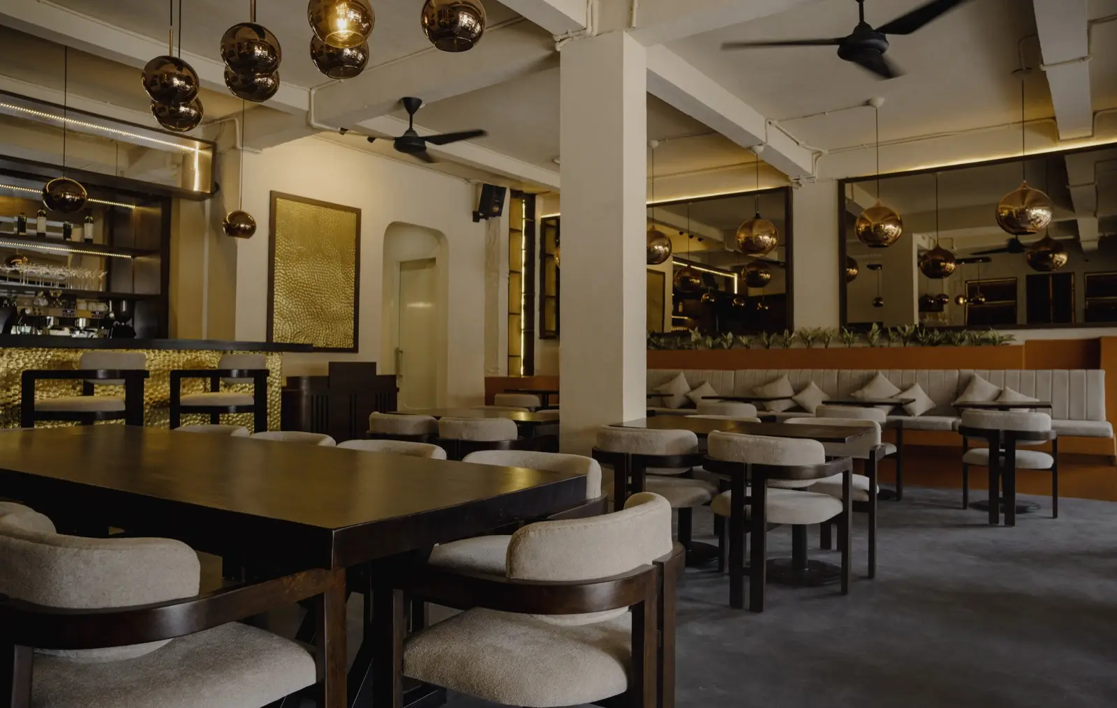 Main dining room with brass pendant lamps and cream chairs