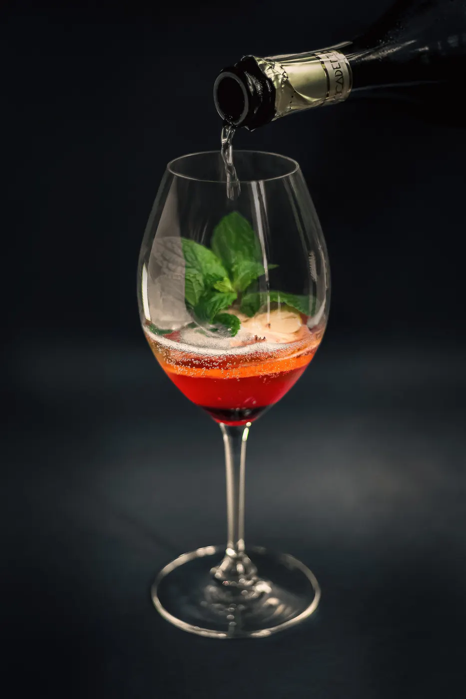 Spritz with fresh mint being poured into a wine glass