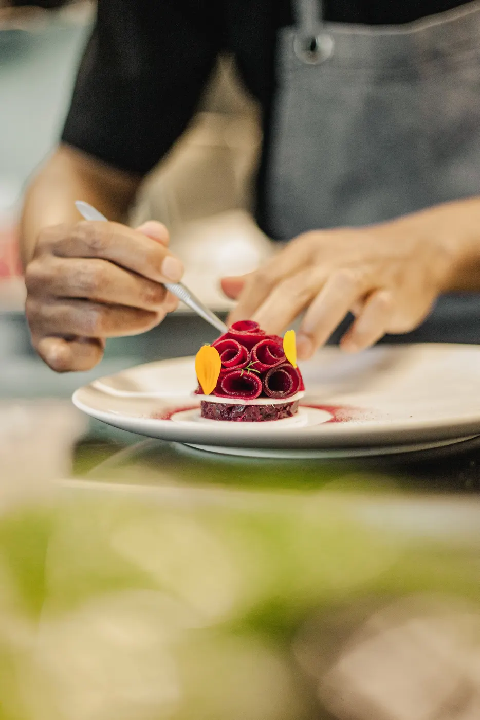Hands placing a pink dessert on a plate