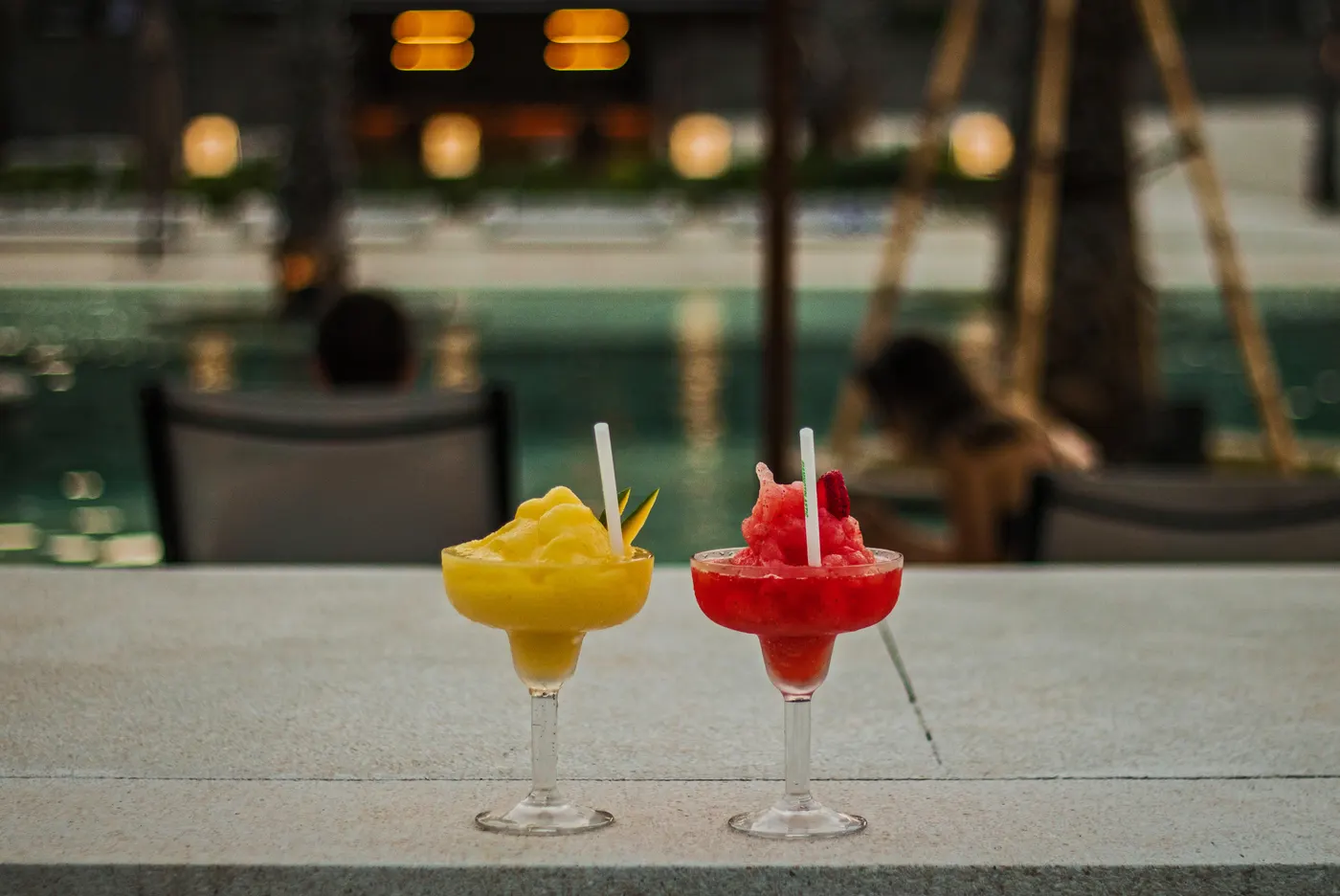 Two frozen cocktails on the pool edge