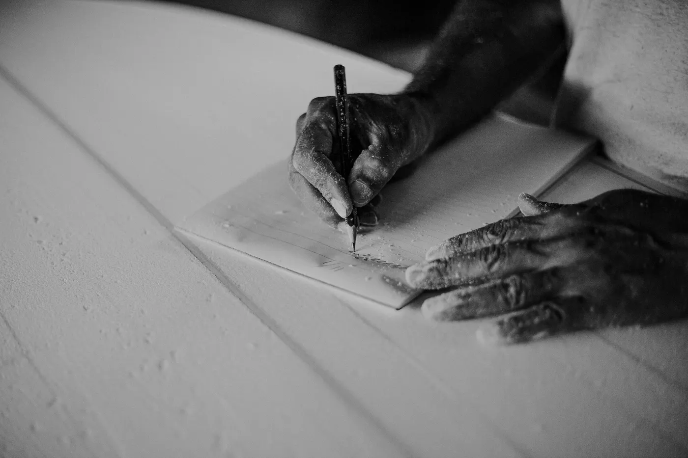 Hand drawing a line on a pale board, black and white