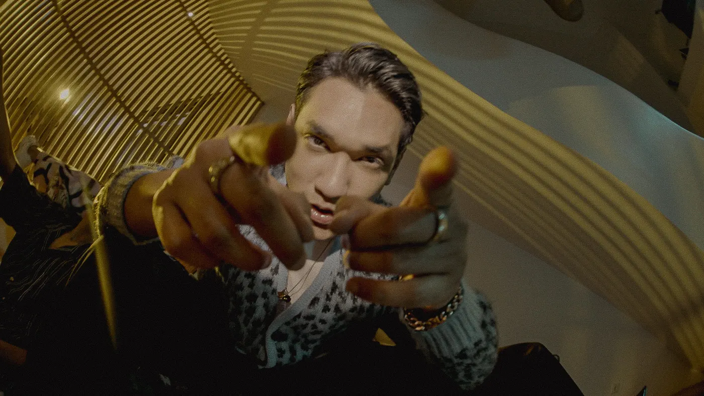 Close shot of Afgan reaching toward the camera, rings on his fingers